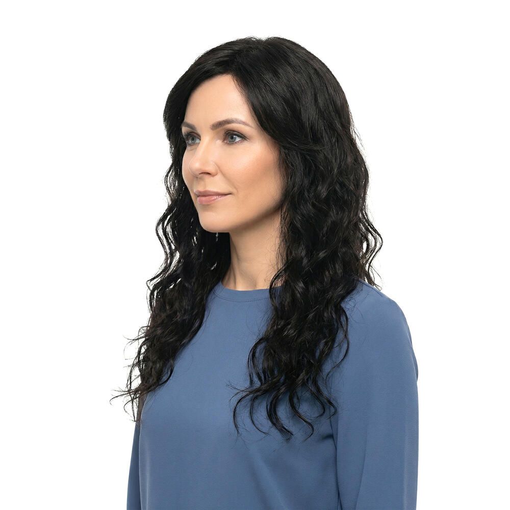 Dunkelbraune Perücke mit gewelltem Haar. Seitenansicht einer Frau mit blauem Oberteil. Hintergrund weiß.