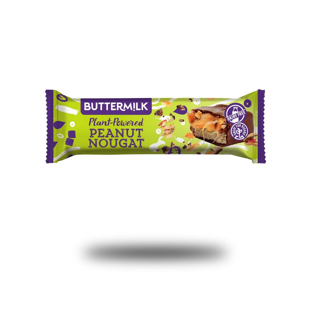 Verpackung mit Buttermilk Plant-Powered Peanut Nougat. Grün-violette Verpackung mit Produktbezeichnung und Logo. Aufschnitt des Riegels.