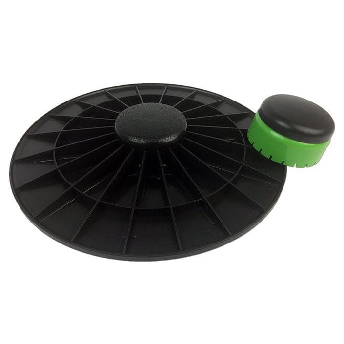 Schwarzes Balanceboard mit grünem Element. Separater, kleinerer grüner Aufsatz. Radial strukturierte Oberfläche.