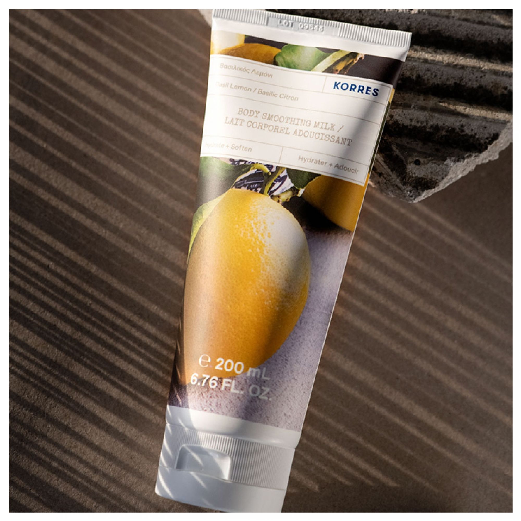 Korres Körpermilch Basilikum Zitrone 200ml Tube, liegend auf strukturiertem Untergrund.