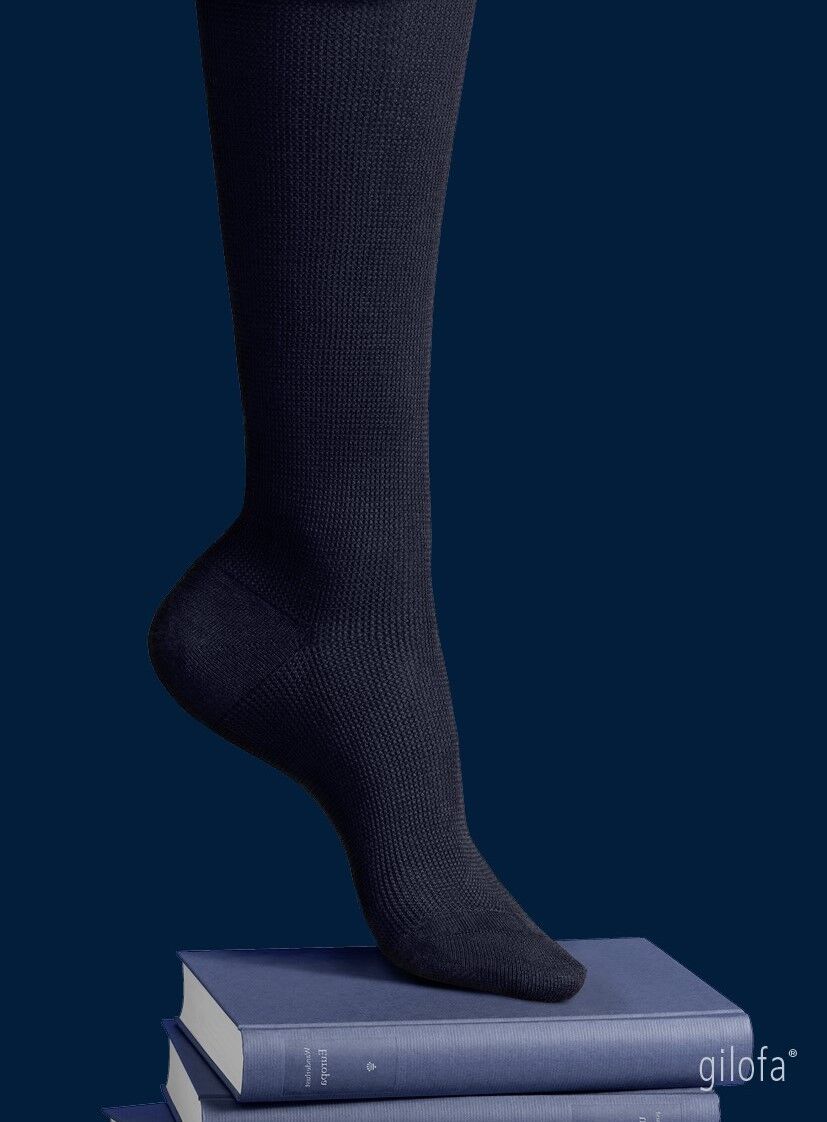 Dunkelblauer Kniestrumpf auf Büchern. Logo 'gilofa'. Dunkelblauer Hintergrund.