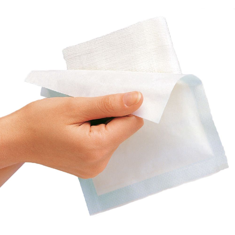 Gazin Mullkompresse, weiß, gefaltet, wird von einer Hand gehalten. Blaue Umrandung. Steril.