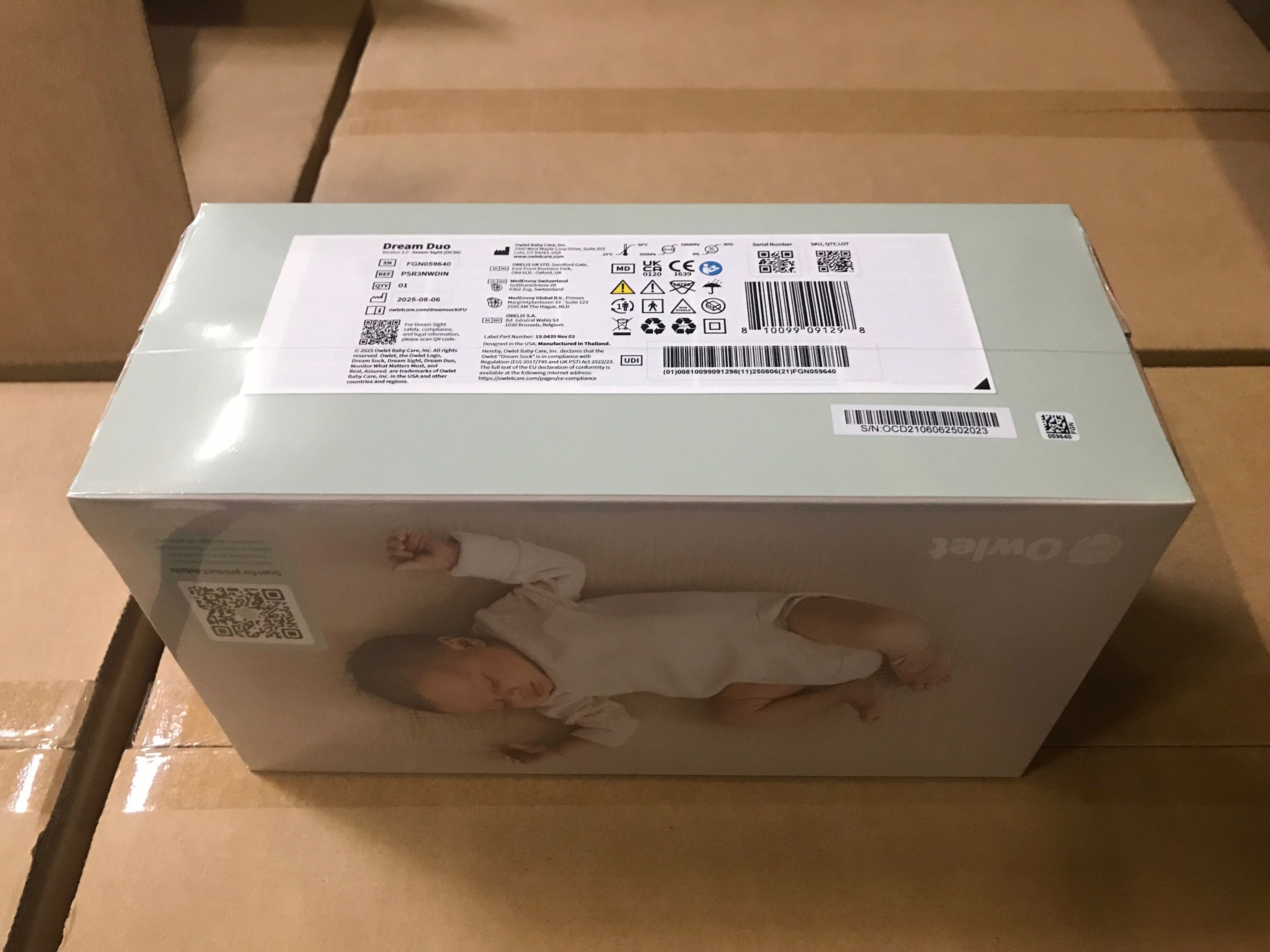 Produktverpackung: Owlet Dream Duo. Baby schläft auf der Verpackung. Text: Owlet, Dream Duo.