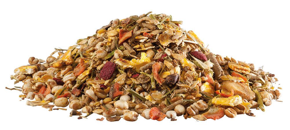 Haufen von Müsli mit verschiedenen Zutaten: Getreide, Samen, Gemüse und Früchte. Auf weißem Hintergrund.