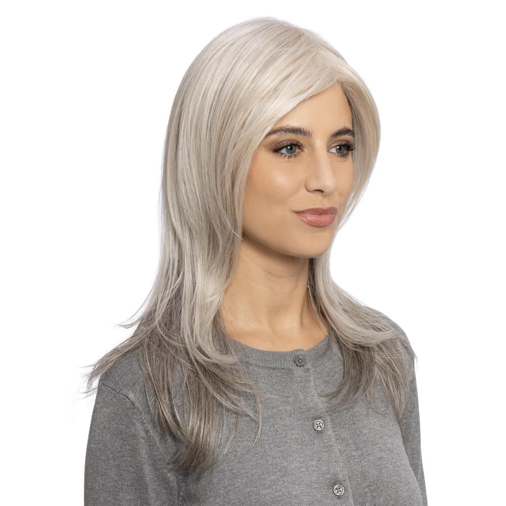 Perücke mit langem, gestuftem Schnitt und Seitenscheitel. Graue Haarfarbe mit dunkleren Spitzen. Frau trägt graue Strickjacke.