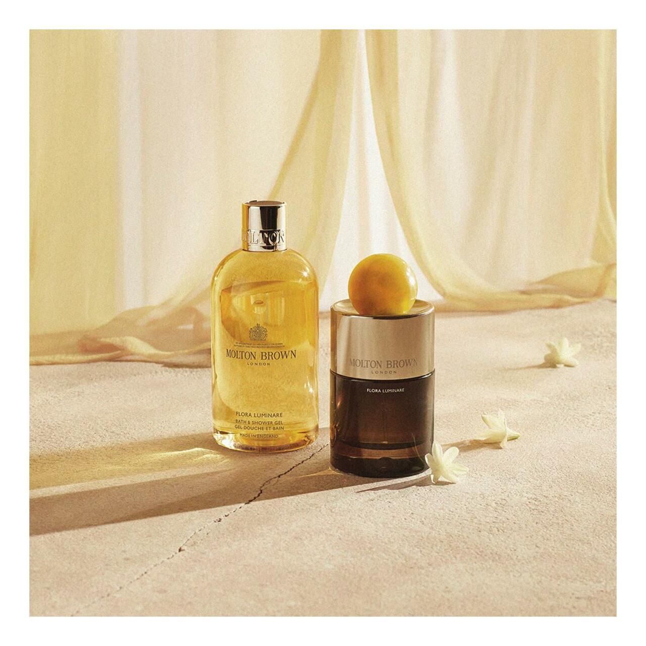 Zwei Flakons auf sandfarbenem Untergrund. Aufschrift: Molton Brown. Eine Flasche mit gelber Flüssigkeit, eine mit dunklerer Flüssigkeit.