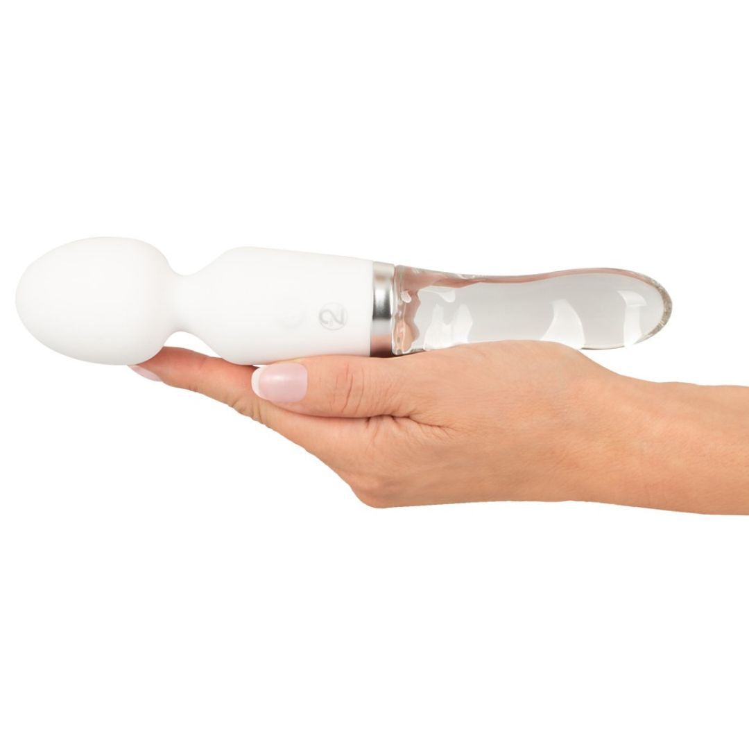Weißer Vibrator, gehalten in einer Hand. Ovale Spitze, gläserner Griff. Metallring. 