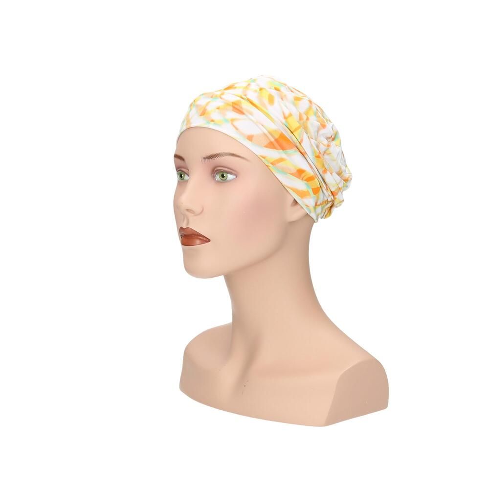 Turban mit gelb-orangem Muster auf einem Schaufensterpuppenkopf. Seitenansicht.