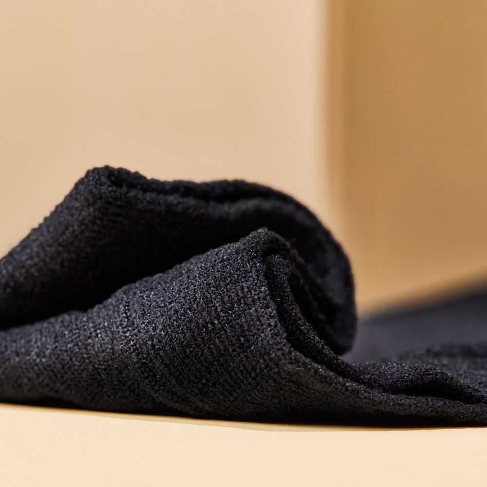 Nahaufnahme einer schwarzen Netzhose. Stoffstruktur sichtbar.