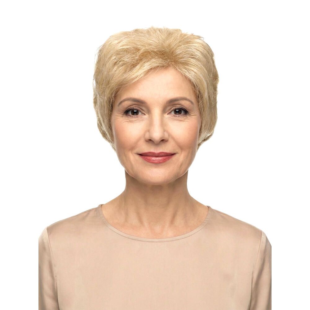 Blonde Perücke, kurze Frisur. Frau mit beigem Oberteil, Blick in die Kamera.