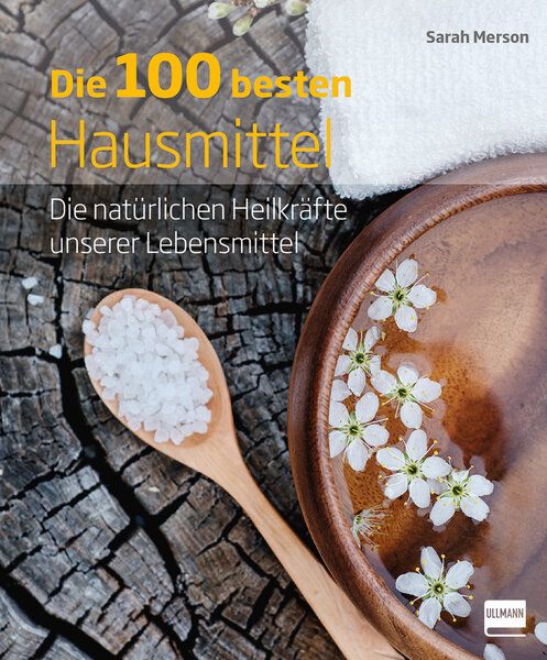 Buchcover: "Die 100 besten Hausmittel". Titel in Gelb. Autor: Sarah Merson. Holzstruktur, Holzlöffel mit Salz, Schale mit Blüten, Handtuch.
