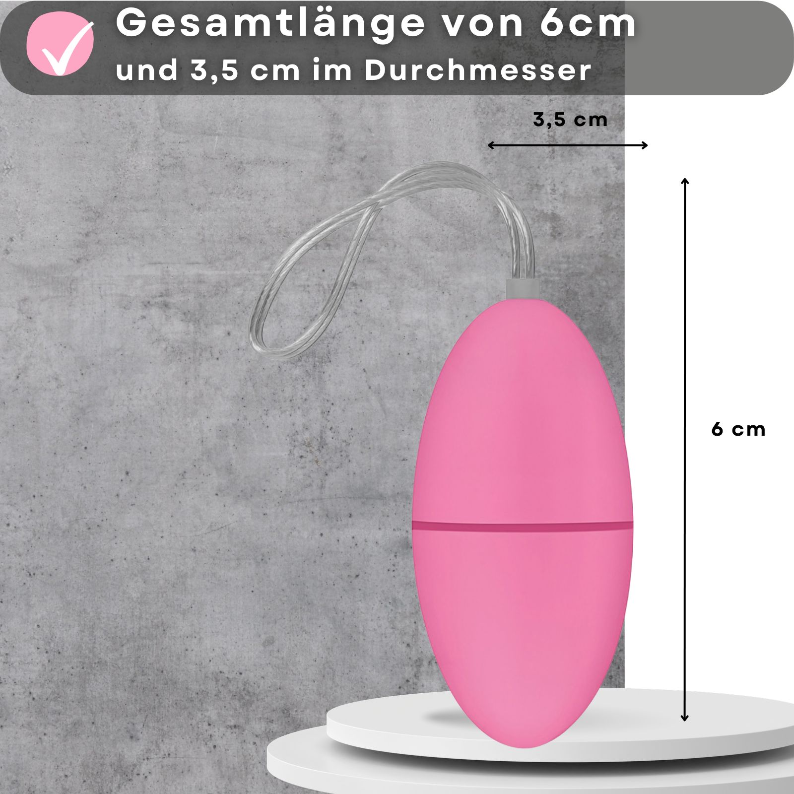 Rosa Ei-Vibrator mit Schnur. Abmessungen: 6 cm lang, 3,5 cm Durchmesser. Auf einer Plattform.