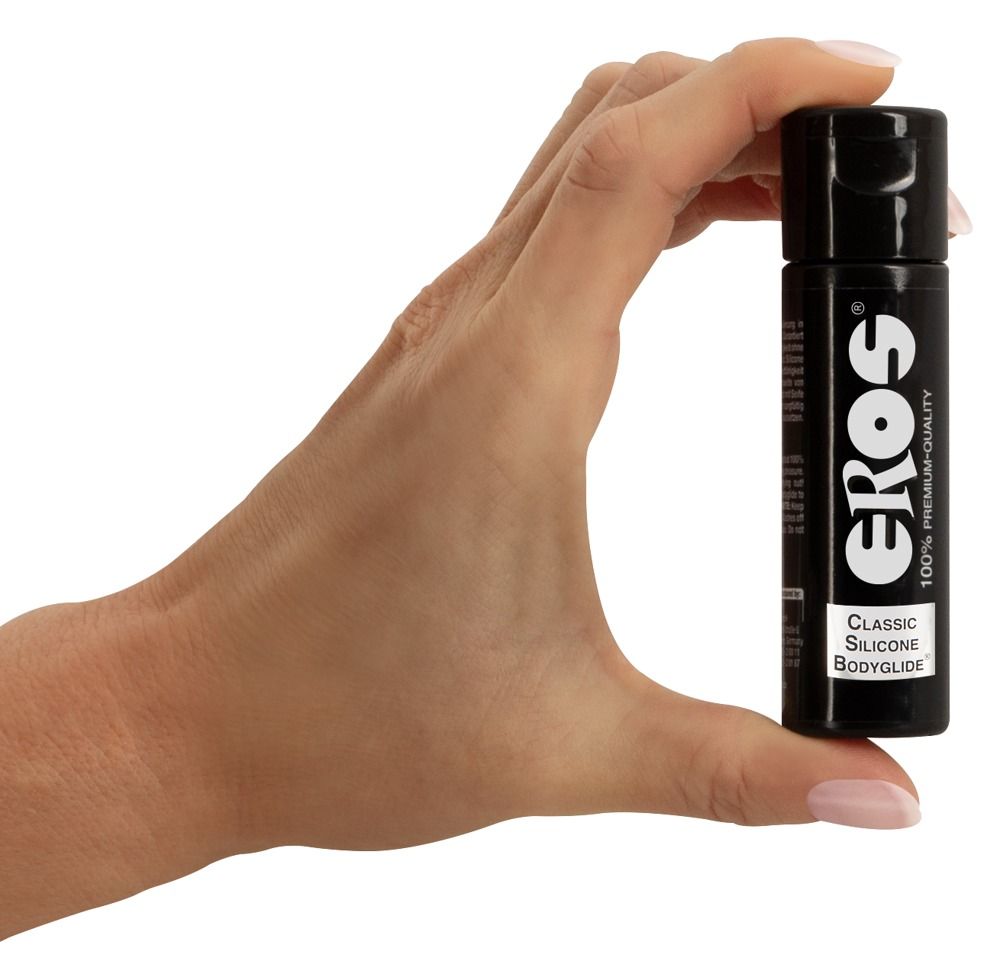 Hand hält eine schwarze Flasche mit schwarzem Deckel. Aufschrift "EROS" und "CLASSIC SILICONE BODYGLIDE".