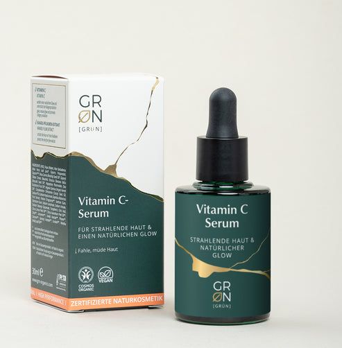 Produktverpackung und Flasche. Aufschrift: Vitamin C Serum, GRØN. Zertifizierte Naturkosmetik. Grüne und goldene Elemente.