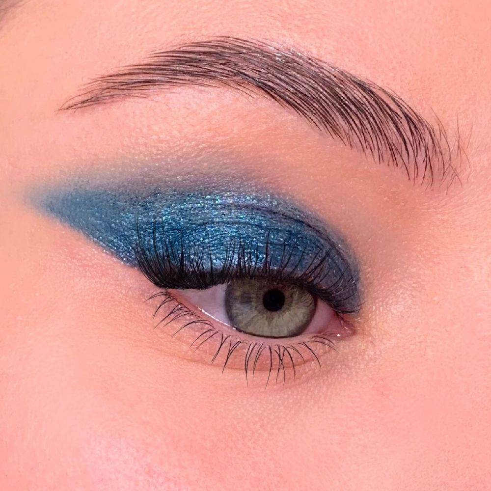 Auge mit blauem Lidschatten. Grünes Auge, blaue Lidschatten-Applikation auf dem Lid.