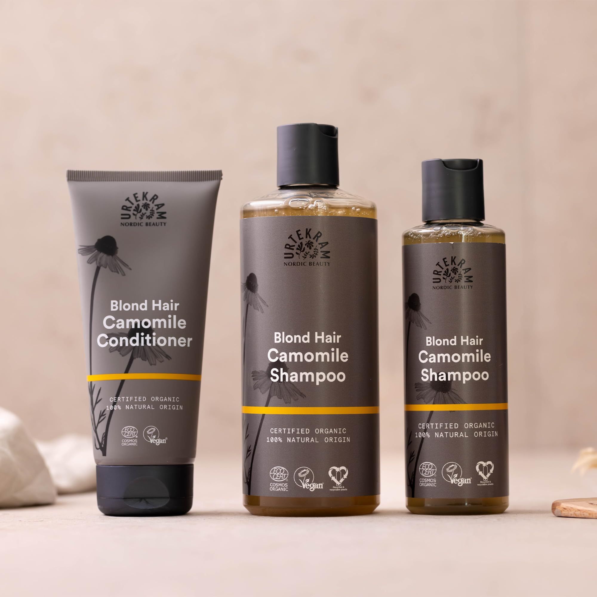 Drei Urtekram-Produkte: Shampoo, Conditioner und Shampoo. Aufschrift: Blond Hair Camomile. Zertifizierungen: Vegan, Organic.