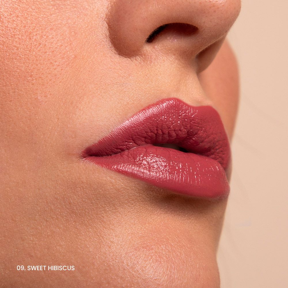Primo piano di labbra con rossetto rosa. Sotto le labbra c'è scritto "09. Sweet Hibiscus".