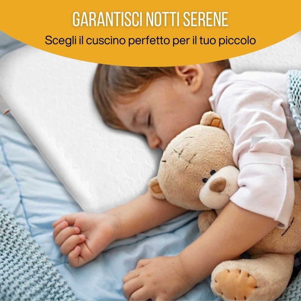 Bambino che dorme su un cuscino bianco. Il bambino abbraccia un orsacchiotto. Lenzuolo blu.