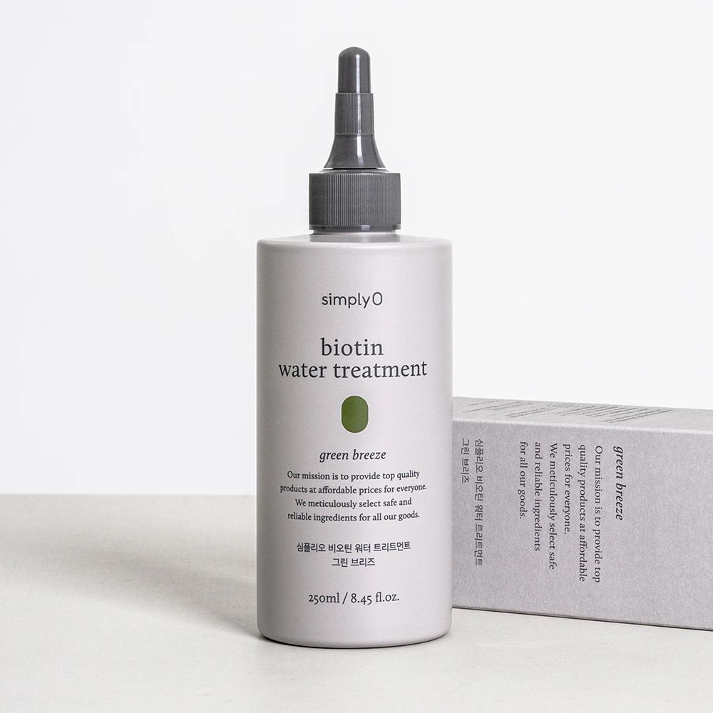 Graue Flasche mit schwarzem Applikator und grauer Verpackung. Aufschrift: SIMPLYO Biotin Water Treatment Green Breeze.