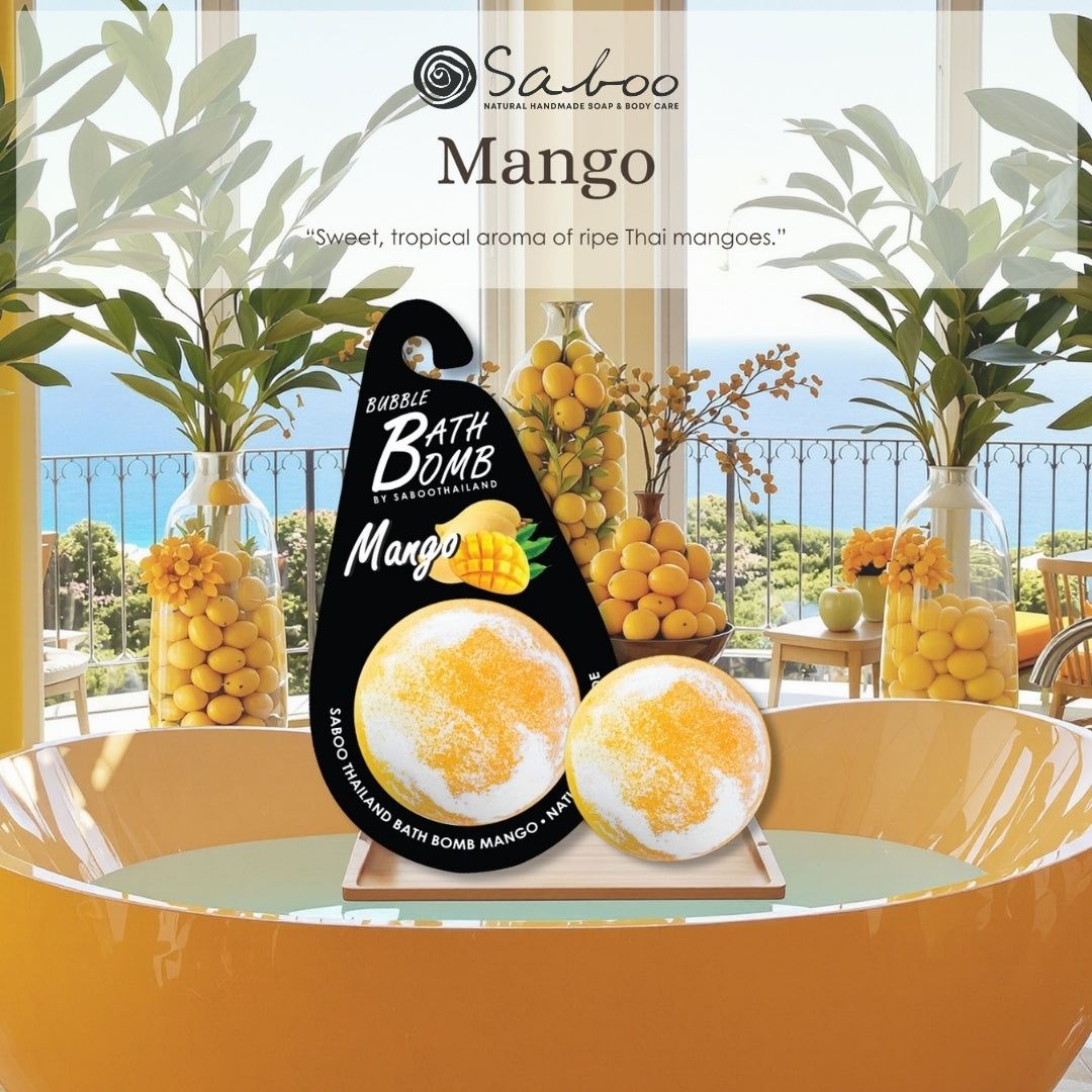 Mango-Badeschaumbombe auf Tablett. Hintergrund: gelbe Badewanne, Vasen mit Früchten. Produktetikett mit Mango-Illustration.