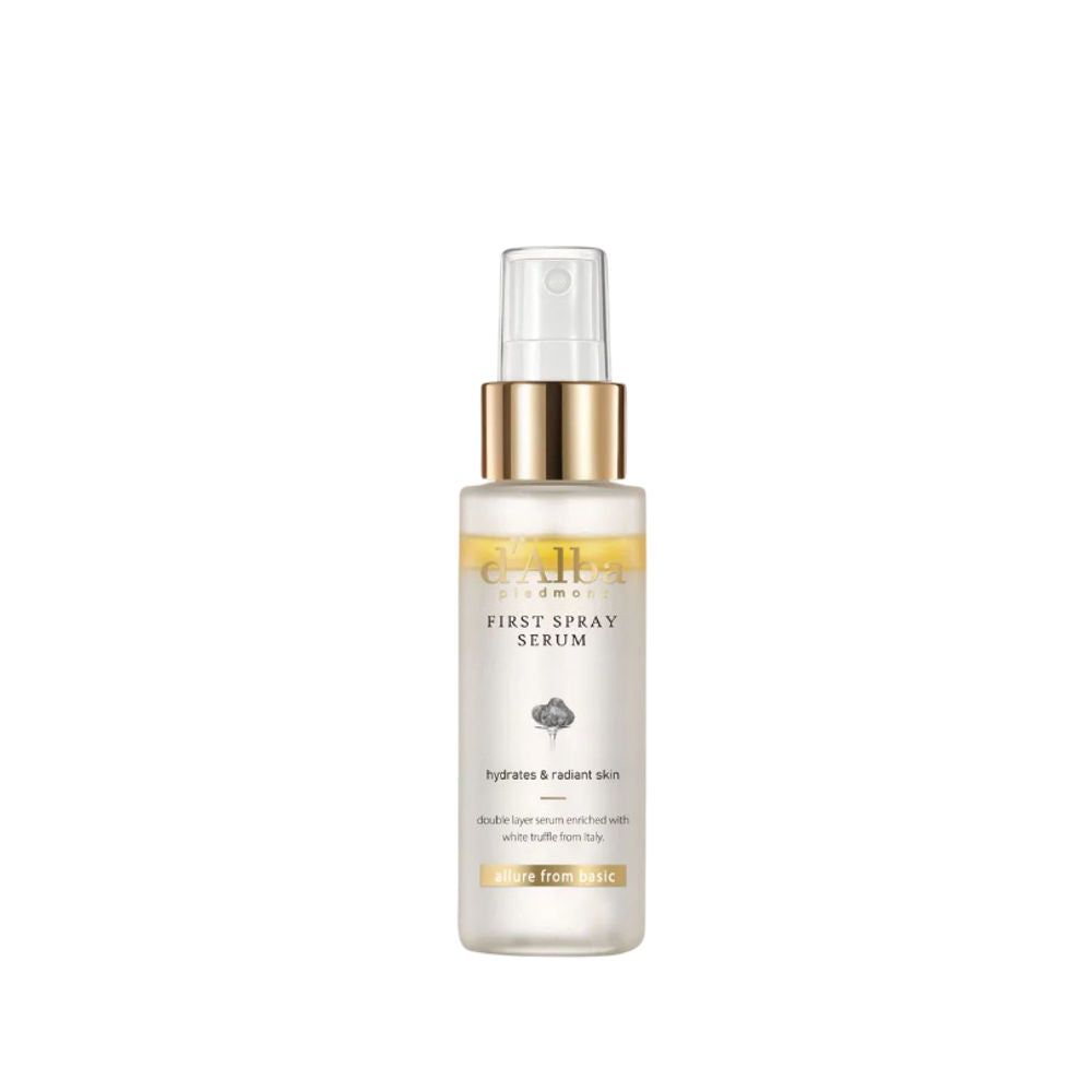Sprühflasche mit goldfarbenem Deckel. Aufschrift: First Spray Serum. Enthält Text über Feuchtigkeit und Ausstrahlung.