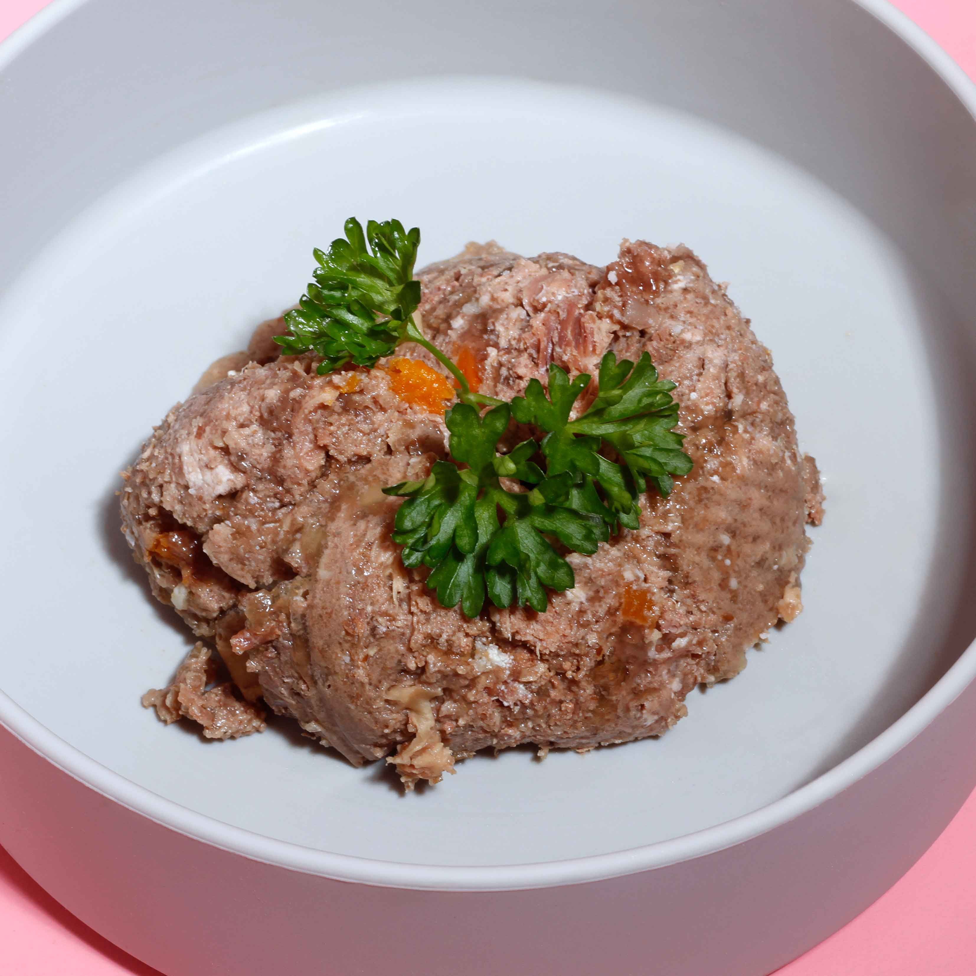 Helle Schüssel mit Fleisch und Gemüse. Dekoriert mit Petersilie.