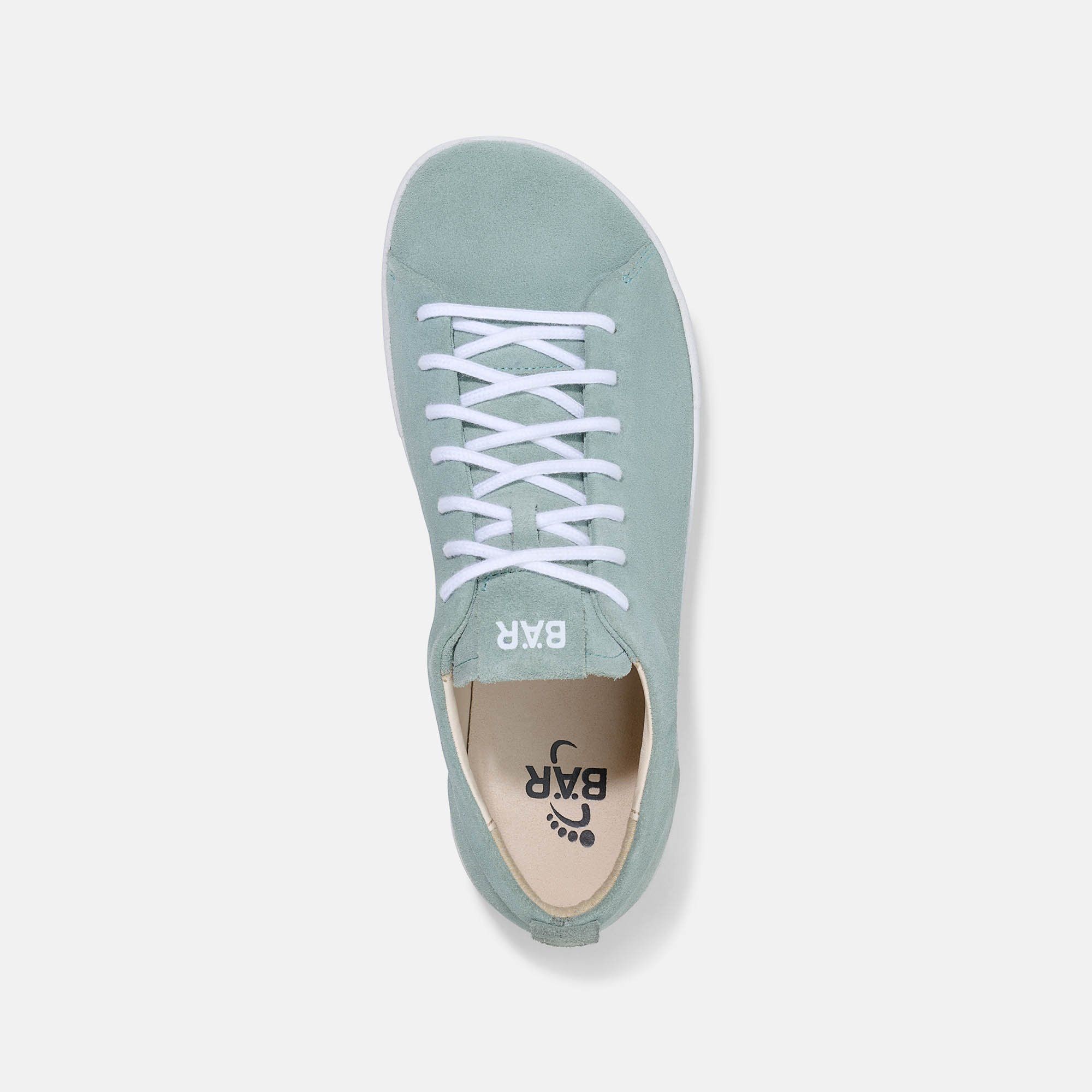 Draufsicht auf einen hellgrünen Sneaker mit weißen Schnürsenkeln. Das Logo "BÄR" ist auf der Zunge und Innensohle sichtbar.