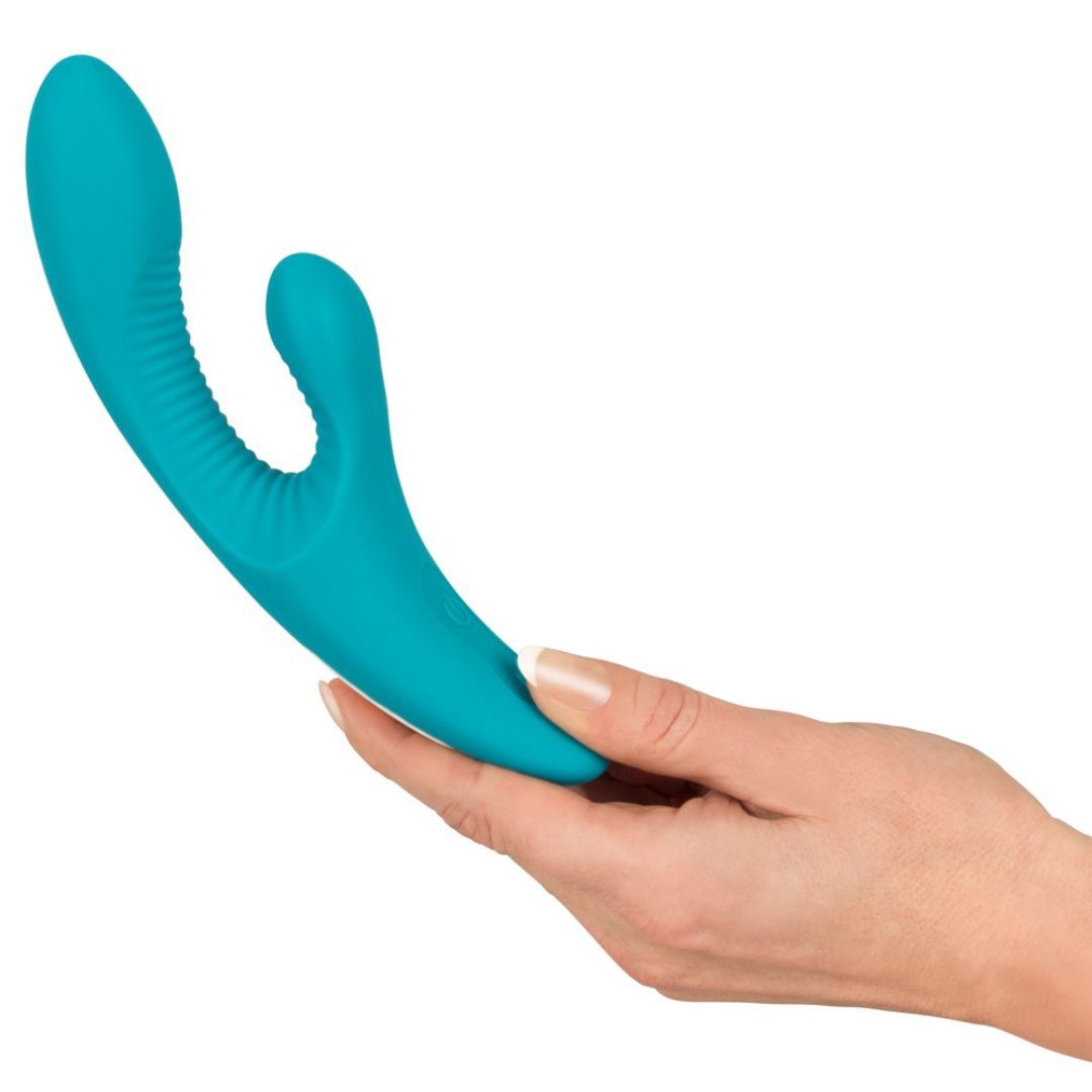 Türkisfarbener Vibrator in einer Hand gehalten. Gebogene Form mit geriffelter Oberfläche.