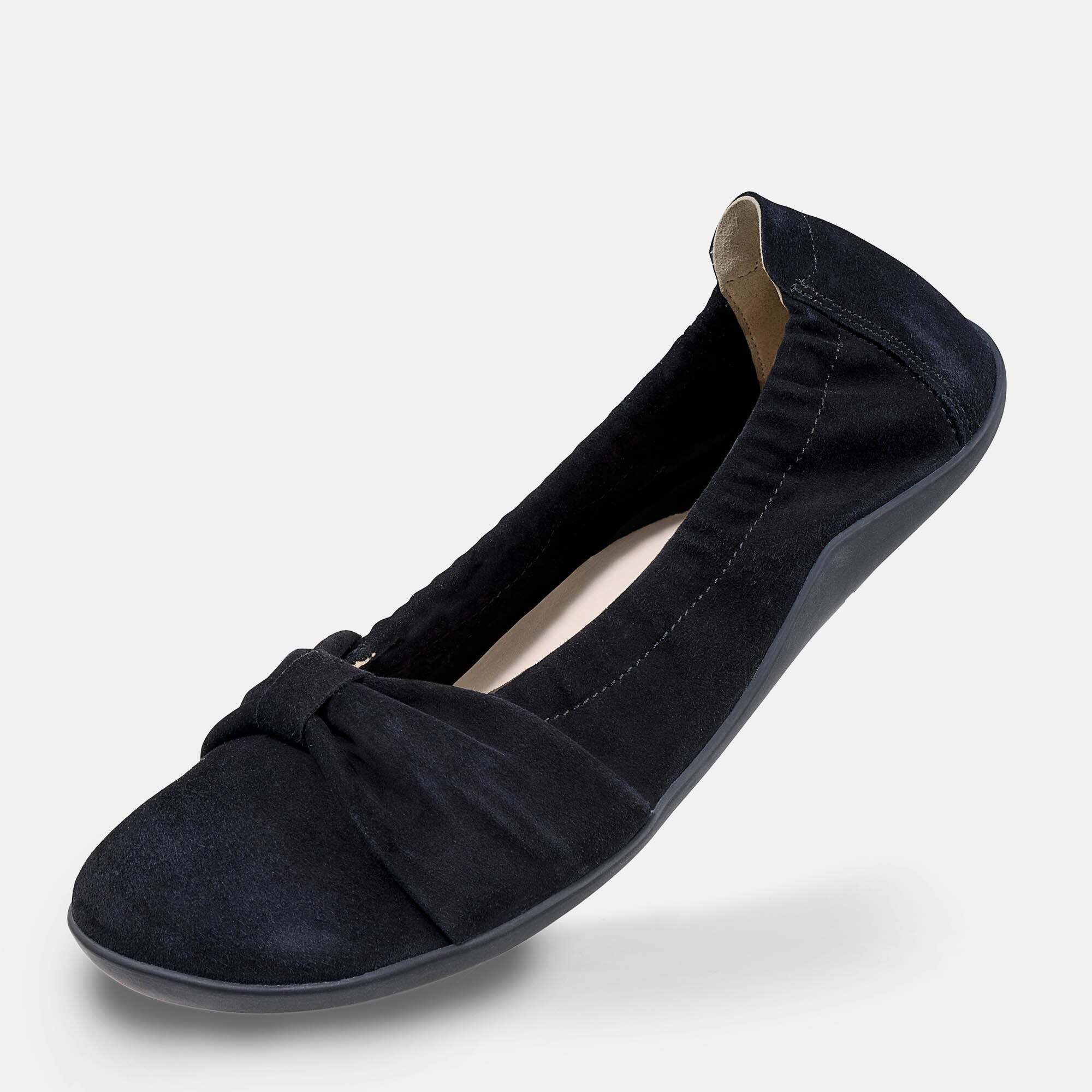 Seitenansicht einer schwarzen Ballerina aus Wildleder mit Schleife und flexibler Sohle.