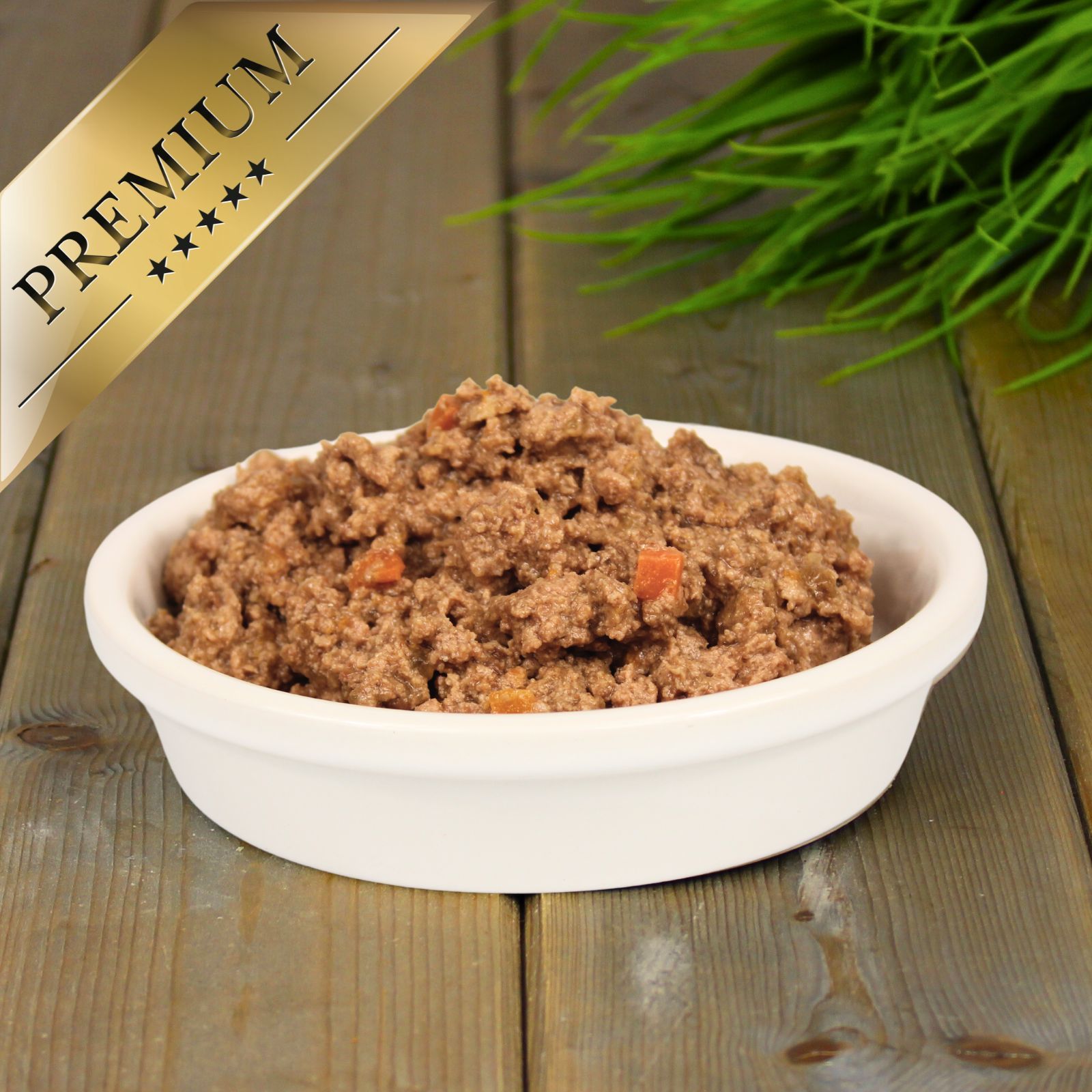 Schüssel mit feuchtem Tierfutter, das aus Fleisch und Karottenstücken besteht. Ein goldener Banner mit der Aufschrift "PREMIUM" ist oben links angebracht.