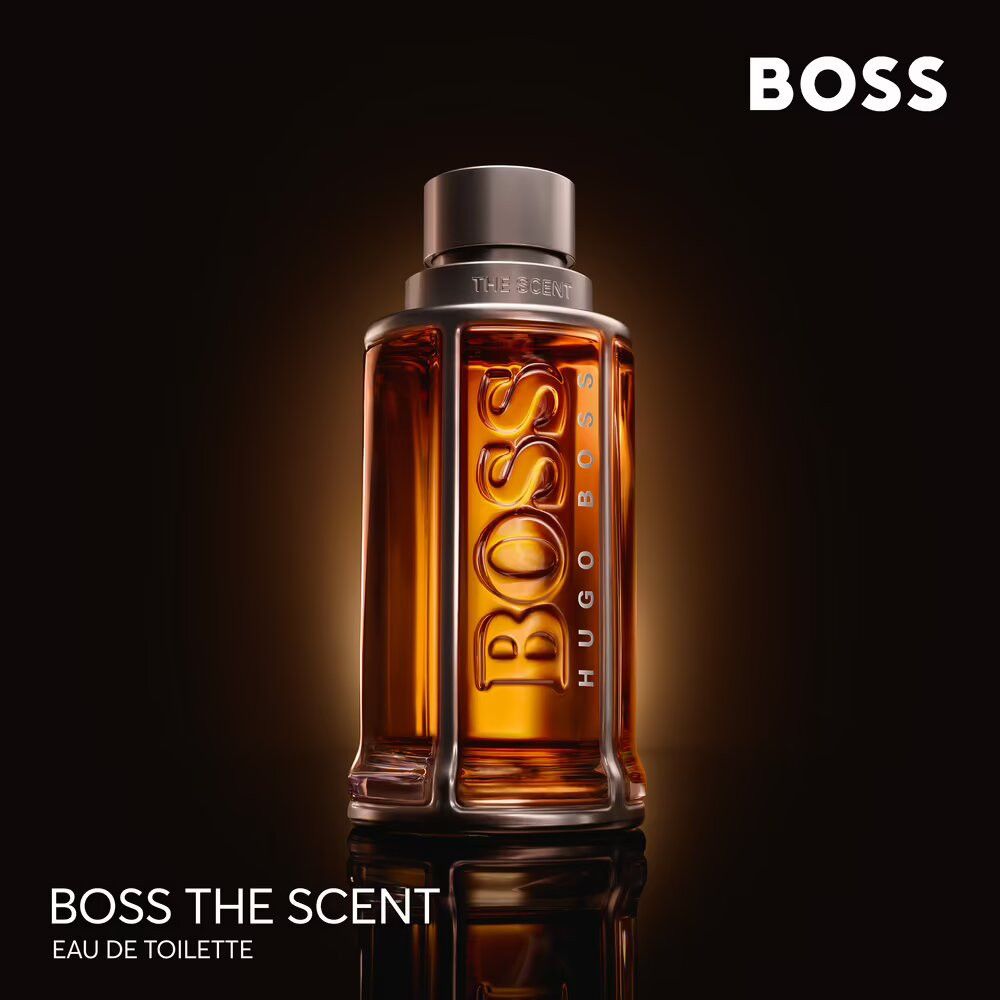 Flakon mit goldfarbener Flüssigkeit. Aufschrift BOSS, HUGO BOSS, THE SCENT. Eau de Toilette.