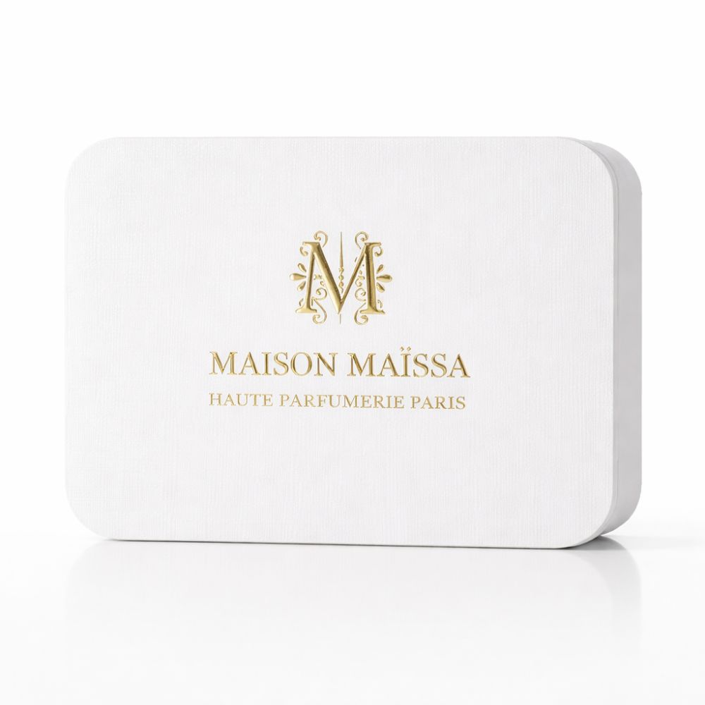 Weiße, rechteckige Verpackung mit abgerundeten Kanten. Goldfarbenes Logo und Schriftzug: MAISON MAÏSSA, HAUTE PARFUMERIE PARIS.