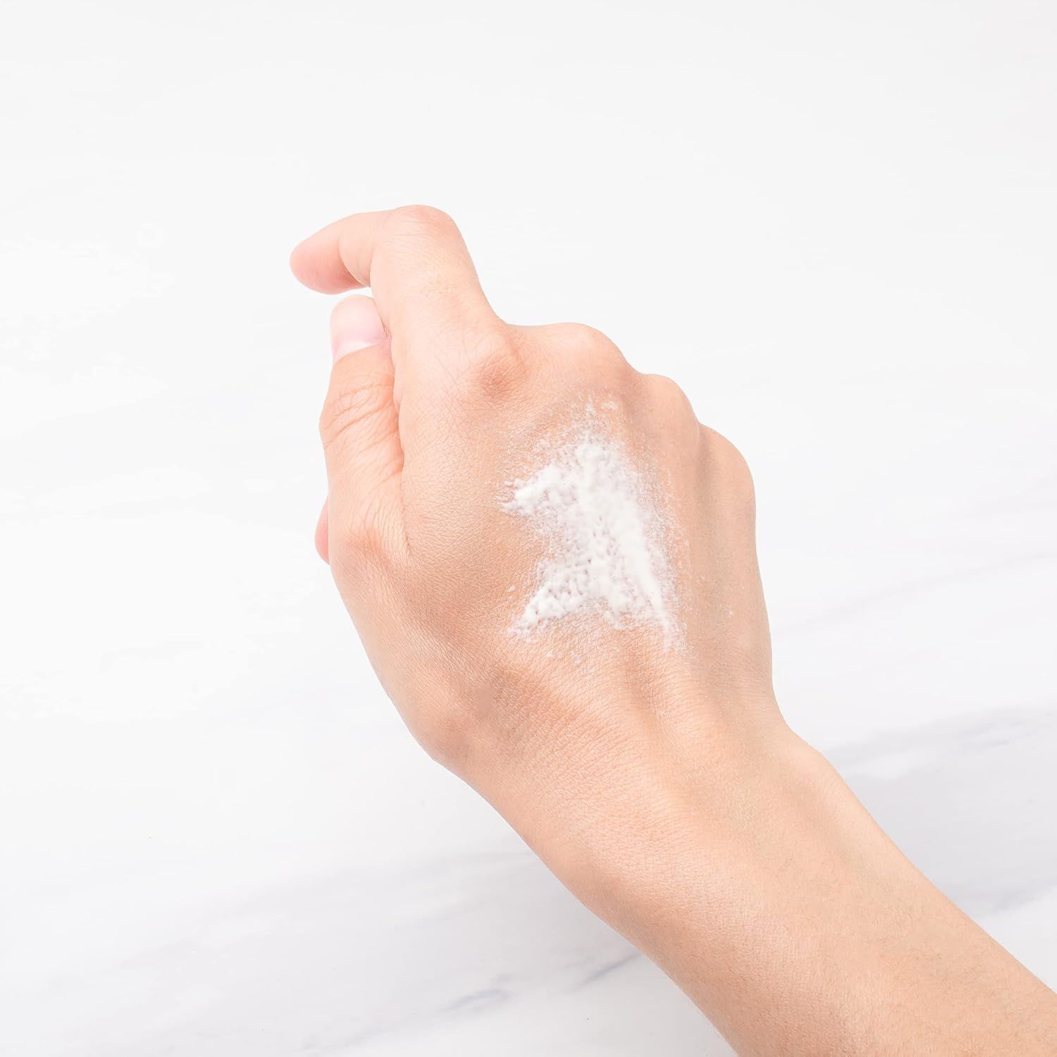 Hand mit weißem Pulver.