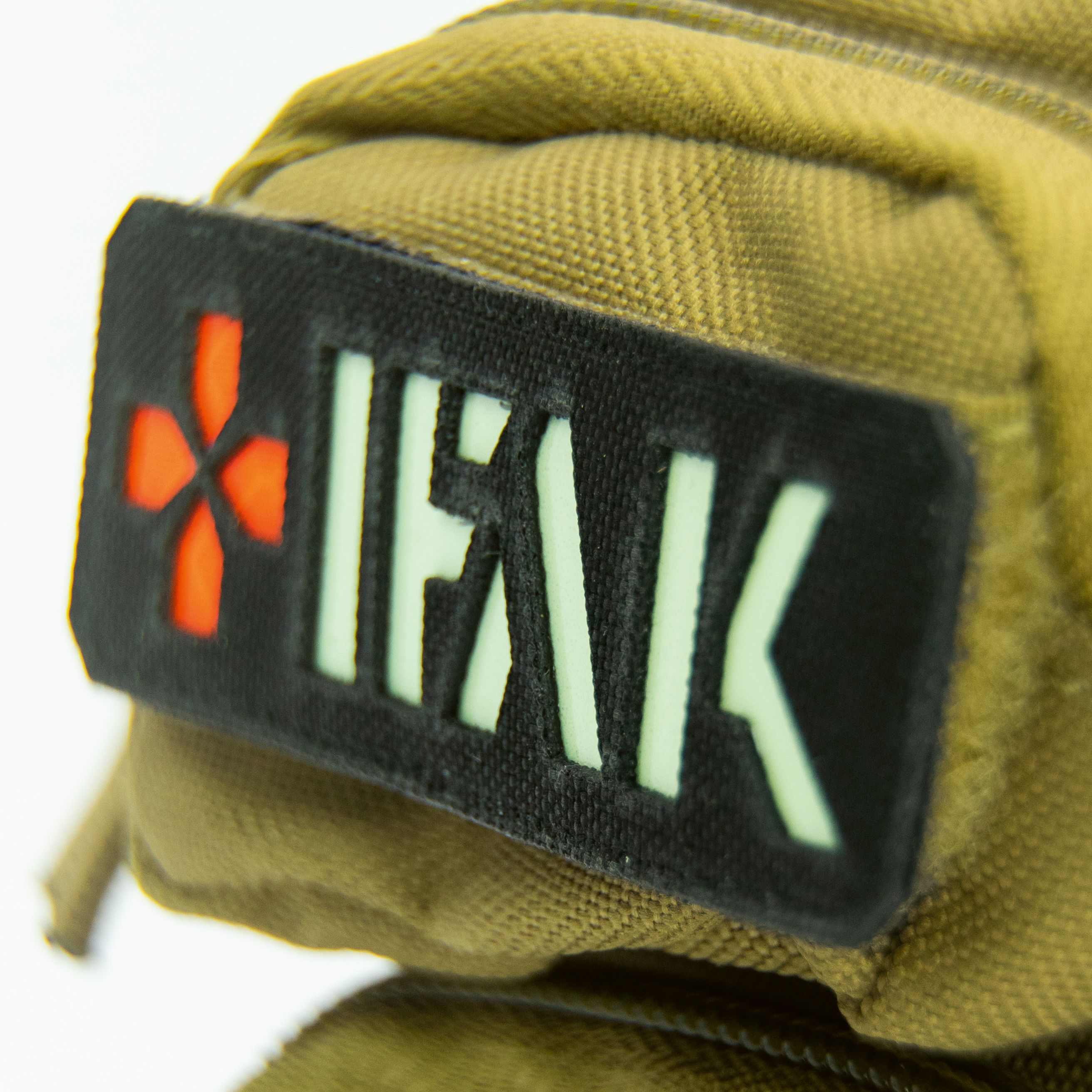 Nahaufnahme des IFAK-Patches auf einem beigefarbenen Notfallrucksack. Der Patch zeigt ein rotes Kreuz und den Schriftzug IFAK.
