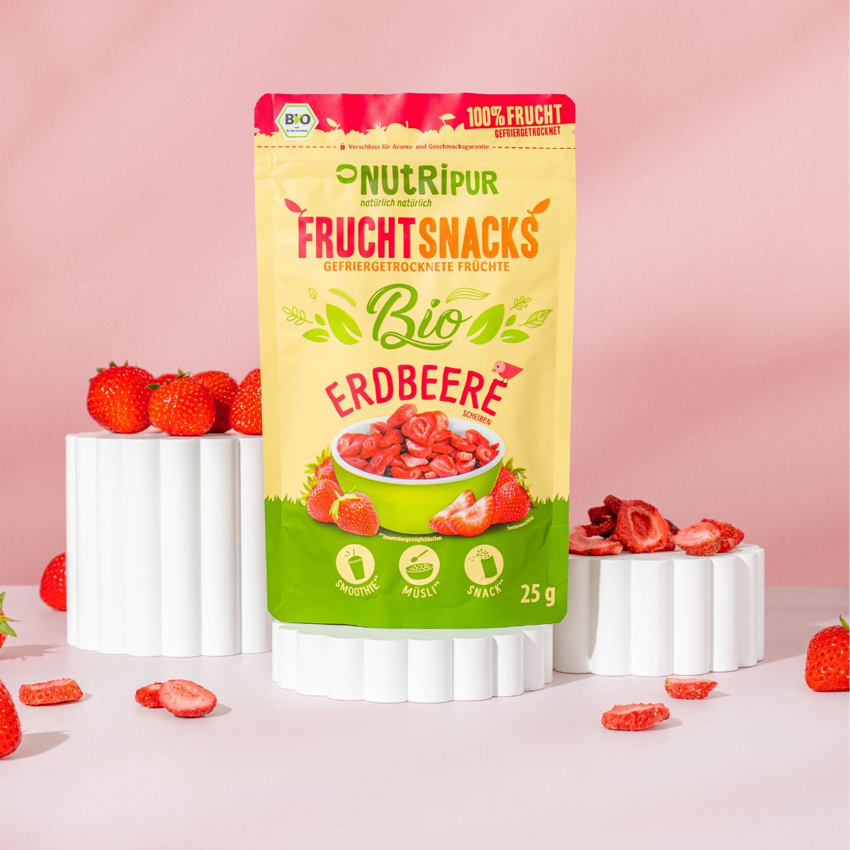 Verpackung NutriPur FruchtSnacks Bio-Erdbeere. Aufschrift: 100% Frucht, Bio, 25g. Erdbeeren auf Podesten.