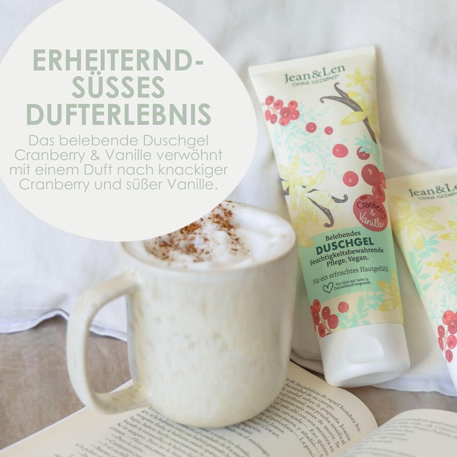 Duschgel-Tuben neben einer Kaffeetasse. Text: "ERHEITERND-SÜSSES DUAFTERLEBNIS". Beschreibung des Duftes Cranberry & Vanille.