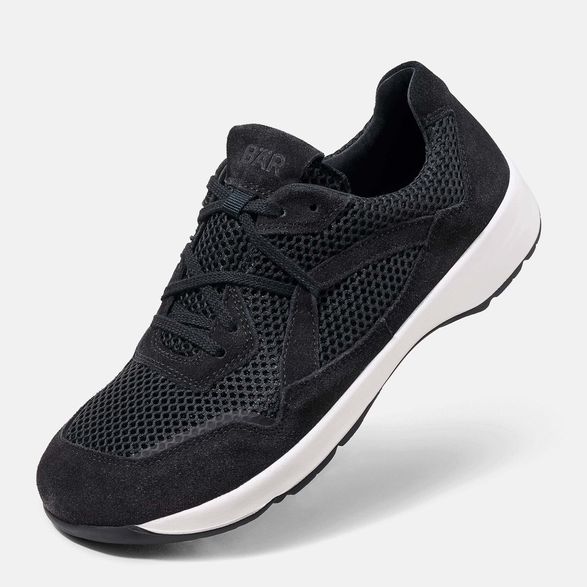 Schwarze Damen-Sneaker mit Mesh-Einsätzen, Schnürung und weißer Sohle.