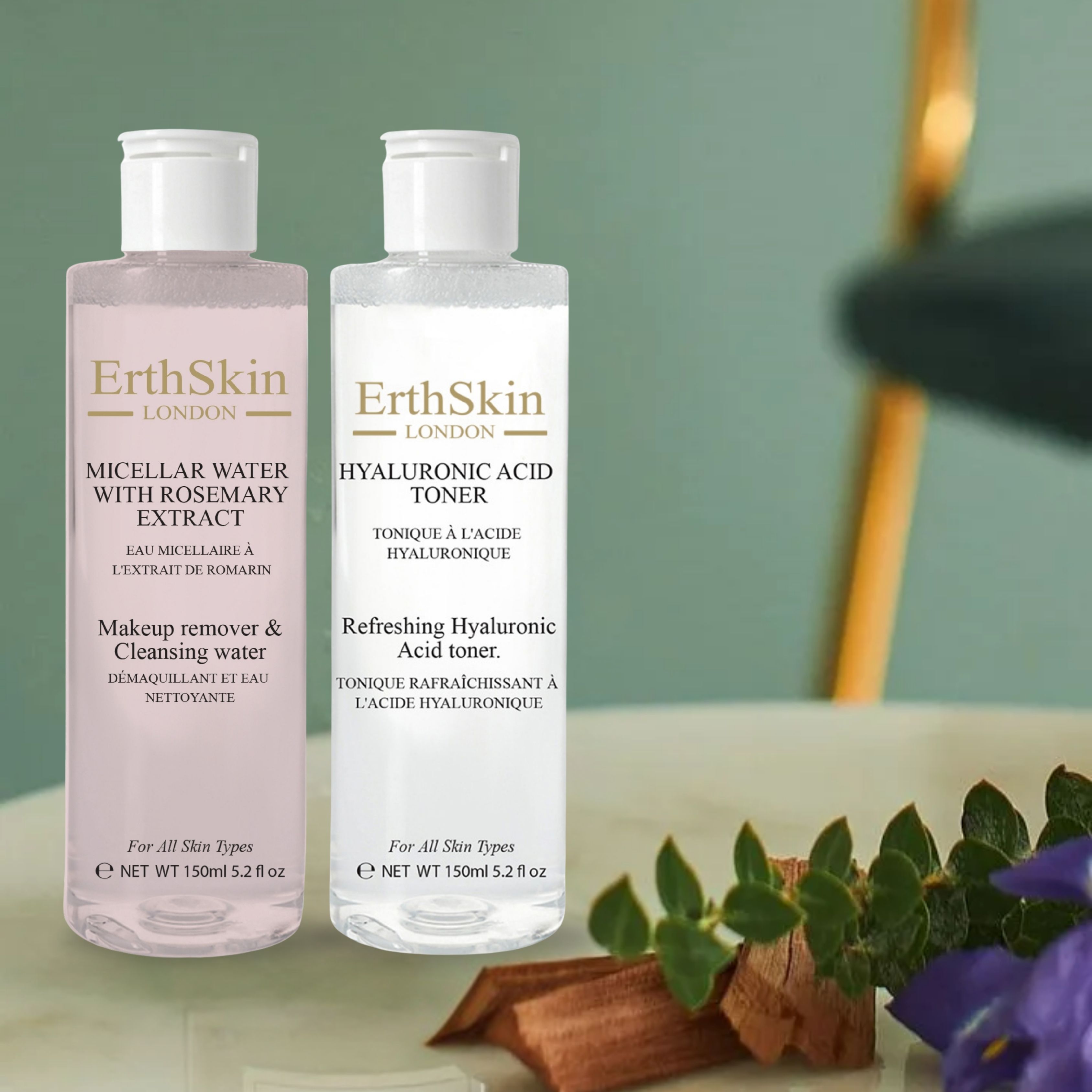 Zwei Flaschen ErthSkin London. Links Mizellenwasser, rechts Hyaluronsäure-Toner. Beide mit weißem Deckel. Auf Tisch mit Dekoration.