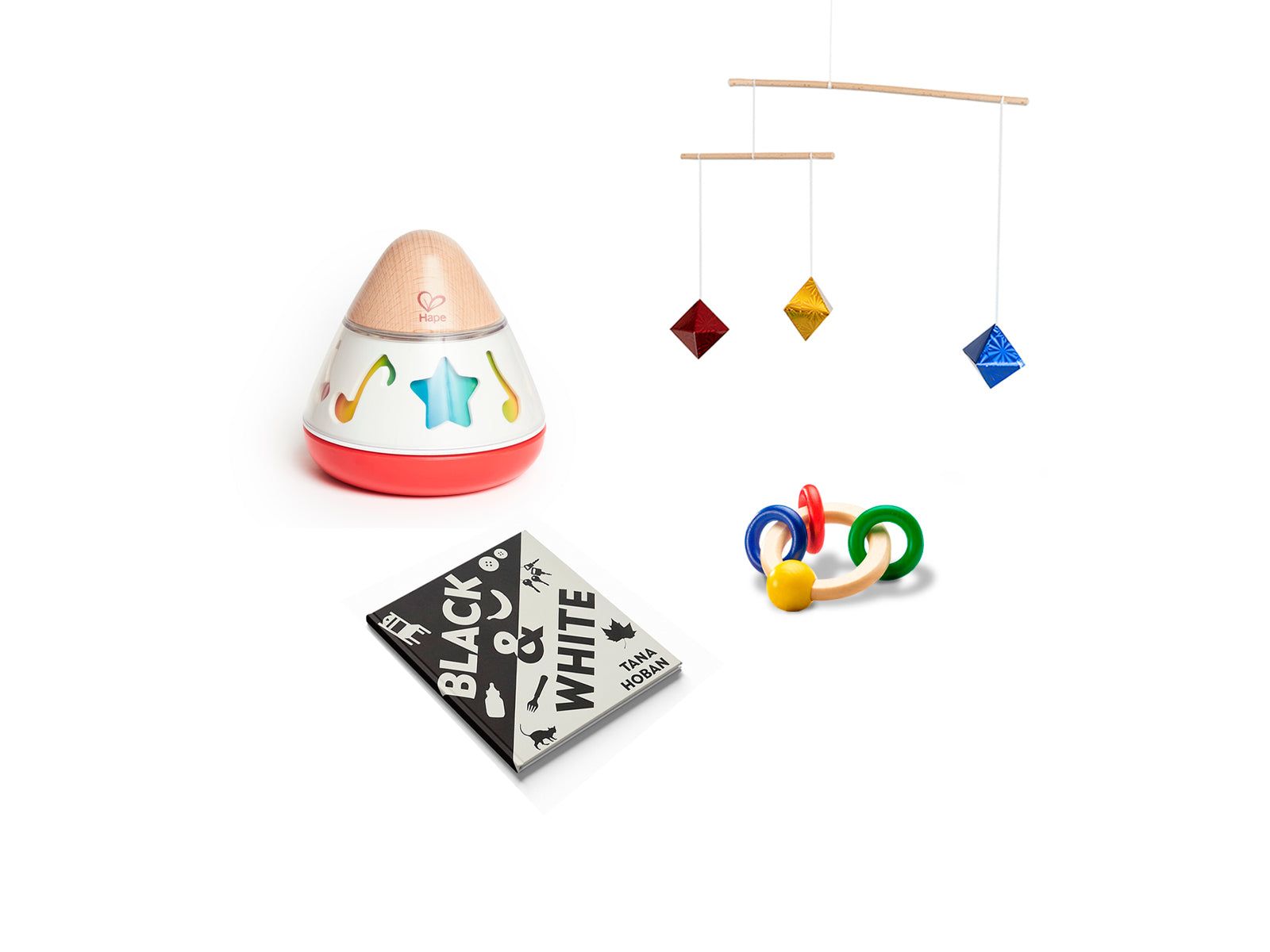 Eine Zusammenstellung von Baby-Spielzeugen: ein Hape-Spielzeug, ein Mobile mit geometrischen Formen und ein Holzrasselring. Außerdem ein Schwarz-Weiß-Buch mit dem Titel 'Black & White'.