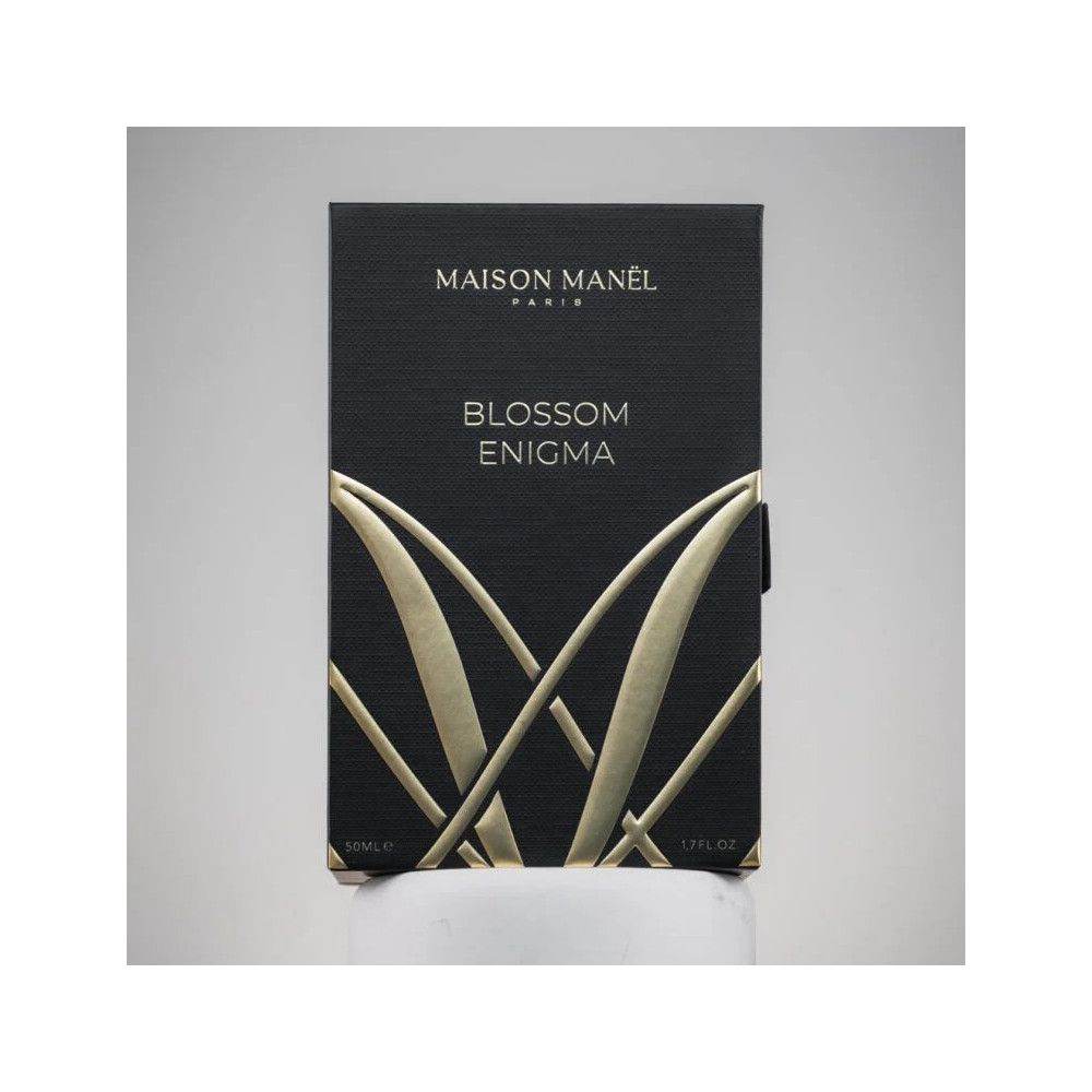 Schwarze Verpackung mit goldfarbenem Logo und Schriftzug Blossom Enigma. Aufschrift: Maison Manel Paris.