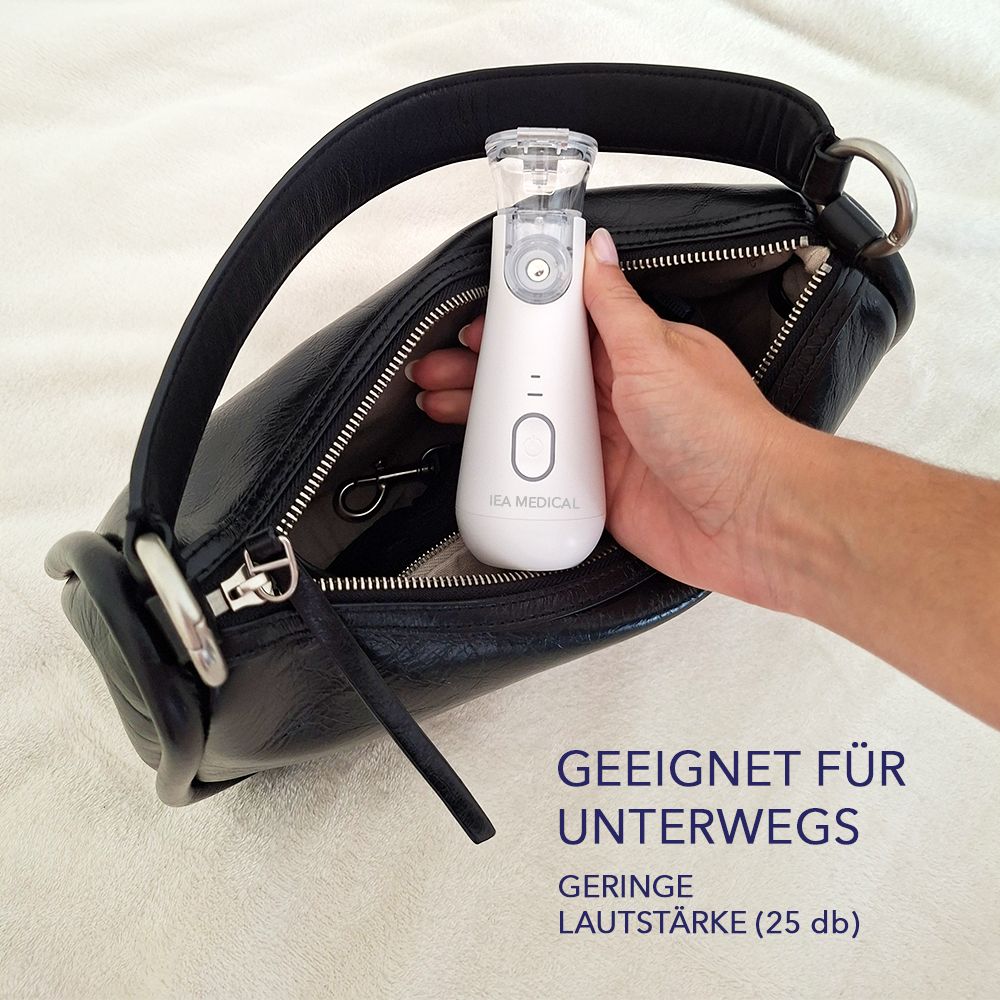 Weißes IEA Medical Inhalationsgerät in einer schwarzen Handtasche. Text: Geeignet für unterwegs. Geringe Lautstärke (25 db).