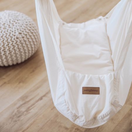 Babyhängematte in beige. Innen mit Kissen. Auf der Vorderseite Label mit swing2sleep.