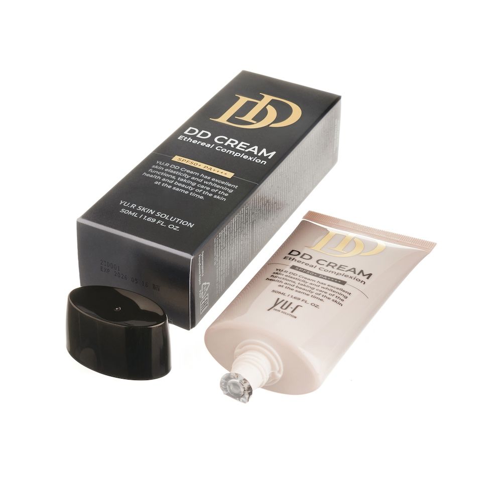 Geöffnete Schachtel und Tube. Aufschrift: DD CREAM Ethereal Complexion. Marke: Yu.r Skin Solution. Schwarzer Deckel liegt daneben.