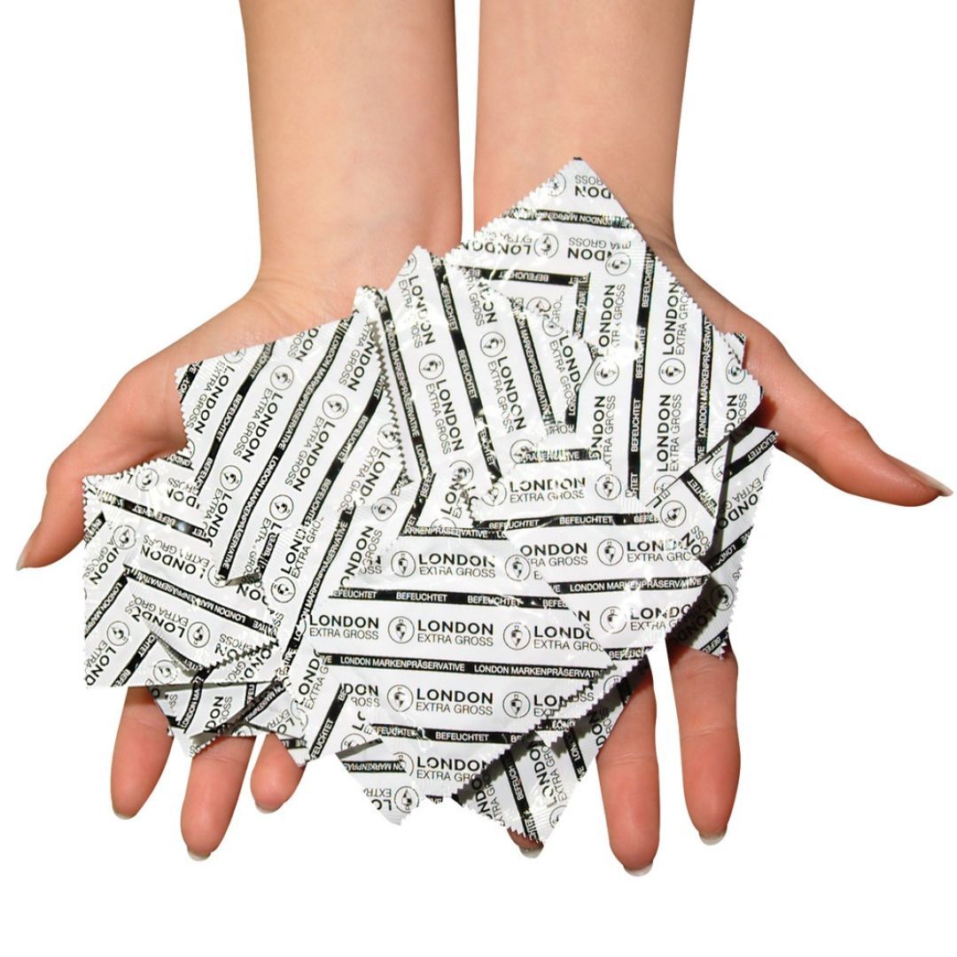 Hände halten mehrere einzeln verpackte Kondome. Verpackung mit Logo und Schriftzug 'London Extra Groß'.