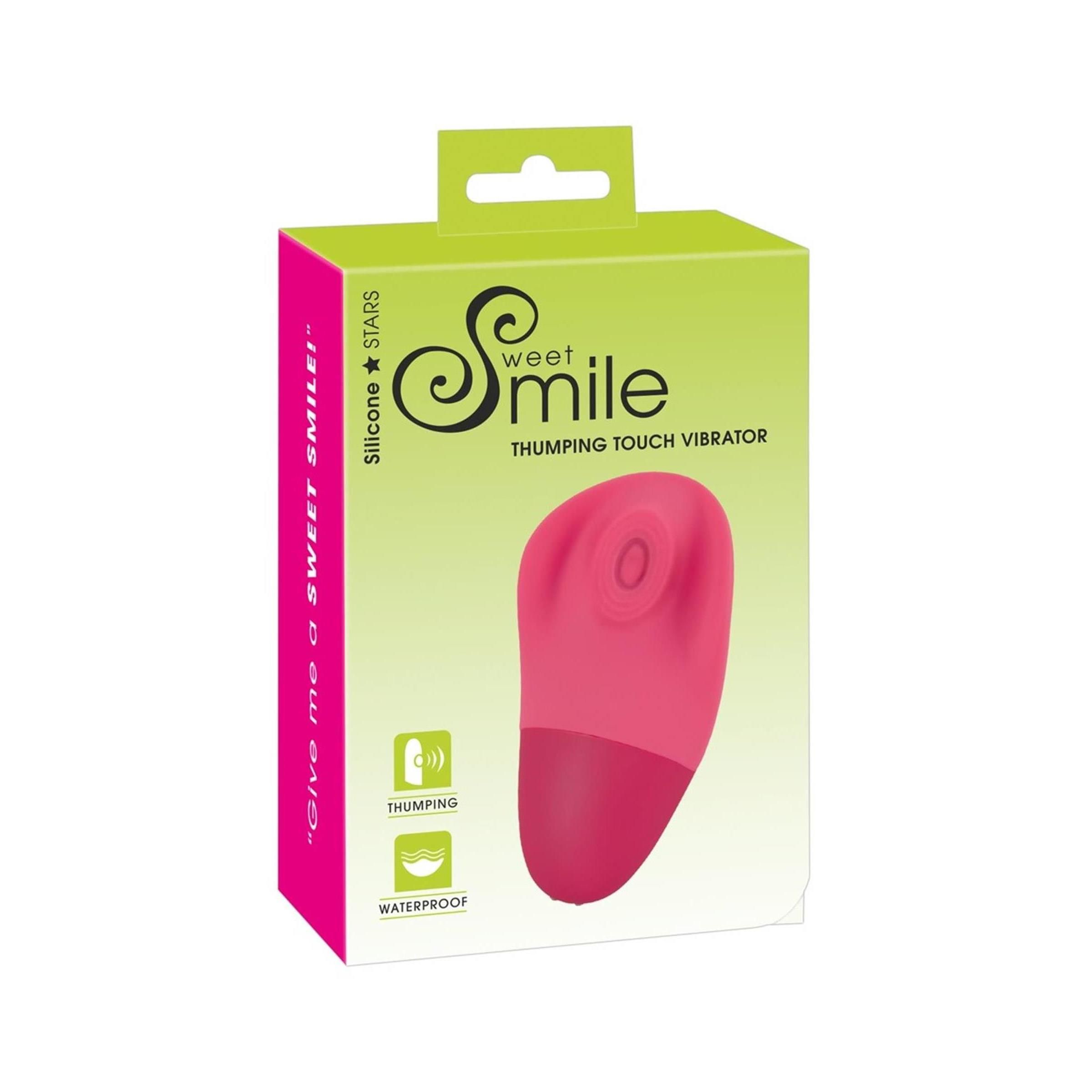 Verpackung mit Produkt. Aufschrift: Sweet Smile, Thumping Touch Vibrator. Rosa Vibrator, grün-weiße Verpackung.