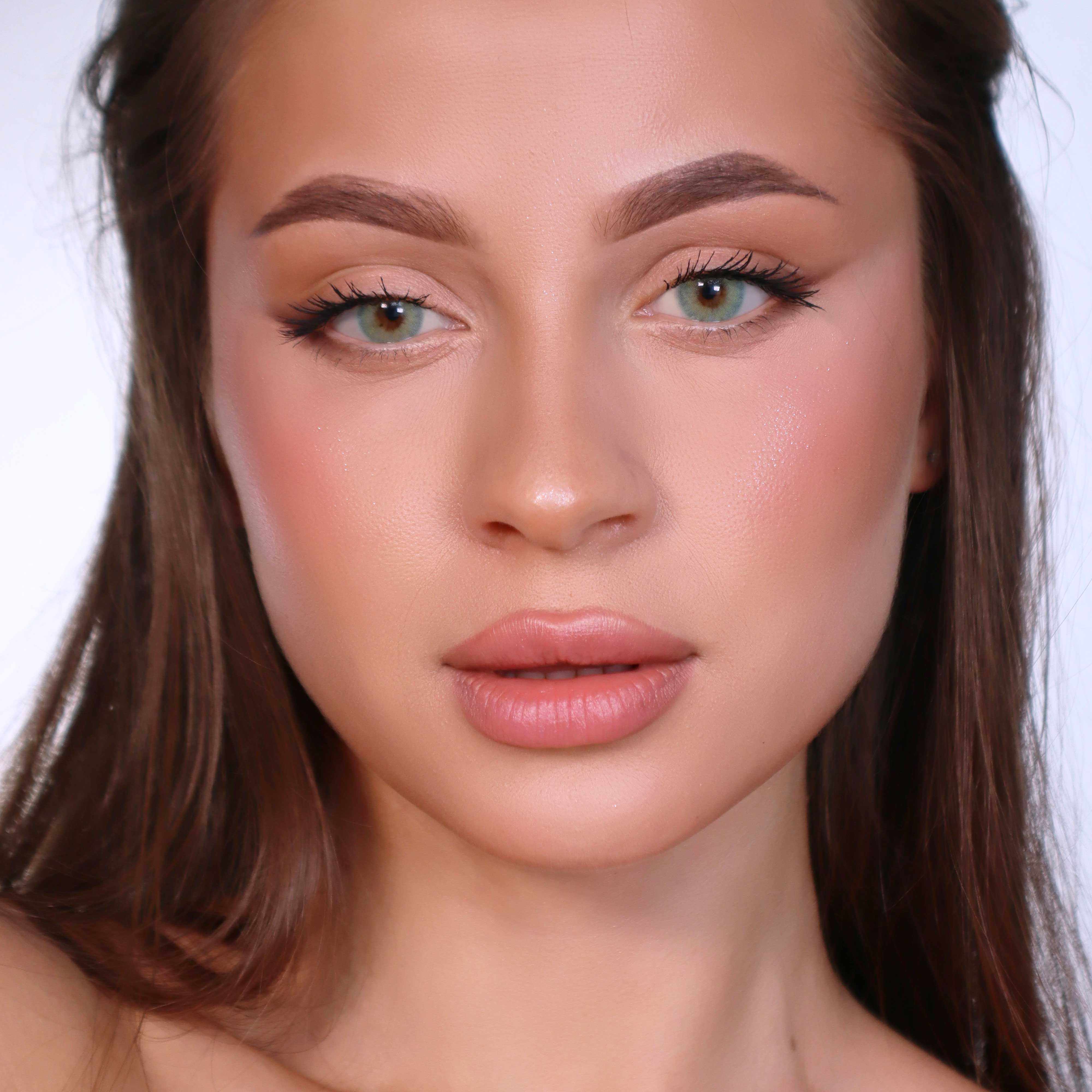 Porträt einer Frau mit grünen Augen. Beide Augen sind mit grünen Kontaktlinsen versehen. Die Augen sind mit Make-up betont.