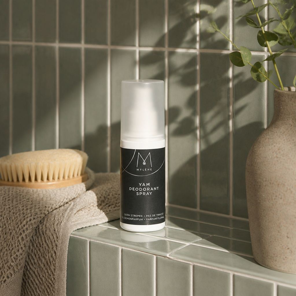 Mylène Yam Deodorant Spray neben einer Bürste und einem Handtuch in einem Badezimmer.