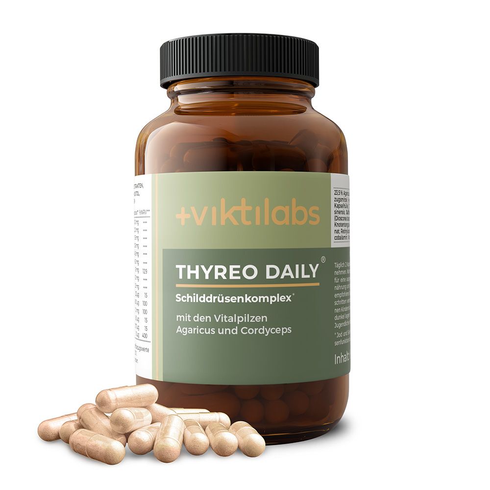 Braunglasflasche mit Viktilabs Thyreo Daily Kapseln und verstreuten Kapseln davor.