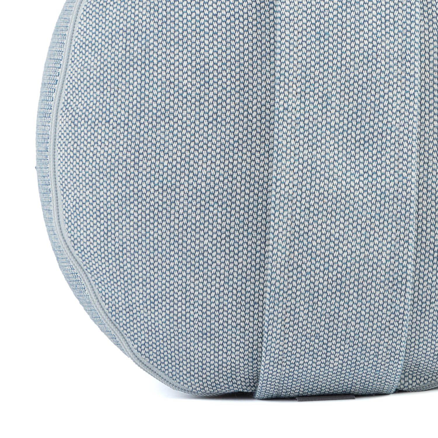 Nahaufnahme eines Yoga-Bolsters. Hellblauer Stoff mit vertikalen Nähten. Runde Form.