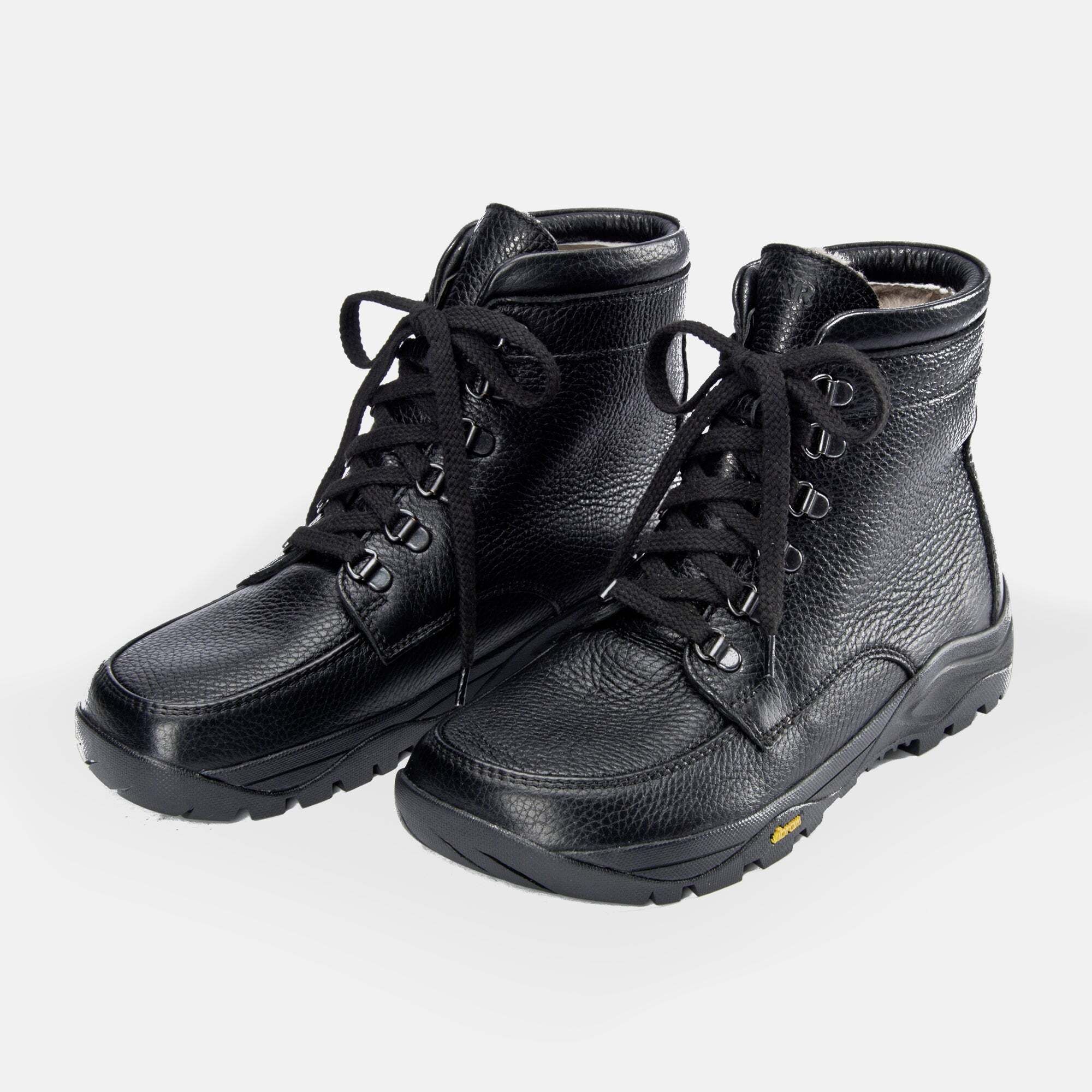 Schwarze Leder-Stiefeletten mit Schnürung, Lammfellfutter und Vibram-Sohle.